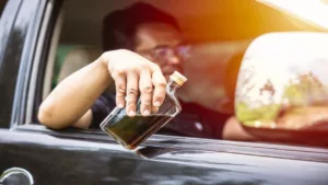 Man Drinking Alcoholic Beverage While Driving a Car 