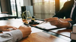 Lawyer Explaining to His Client While Client Holding Pen While Writing