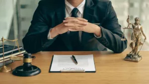  Concepts of Justice and Lawyers Discuss Contract Paperwork with Brass Scales on a Table with a Judge's Hammer Placed in Front of Lawyers in the Office