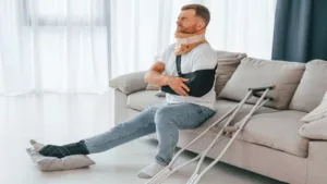 Man with Crutches Is at Home Indoors with Pain in the Arm