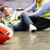 Men Worker Feel Pain and Hurt from the Slip and Fall Accident That Happen Inside of Industrial Factory While His Co-Worker Comes to Give Emergency Assistance and Help