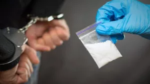 A Police Officer Finds Drugs on a Man Wearing a Sweater and Puts Him in Handcuffs