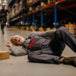 a Man in Uniform Lying Down on the Ground While His Coworker at the Back Ran Toward Him