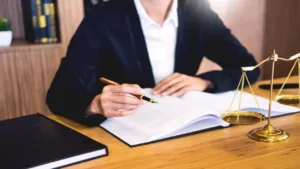 A Woman Lawyer on Her Desk Holding a Pen with Papers